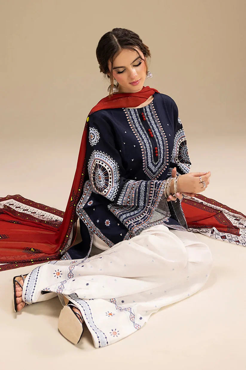 Woman wearing traditional embroidered attire with a red dupatta on a beige background