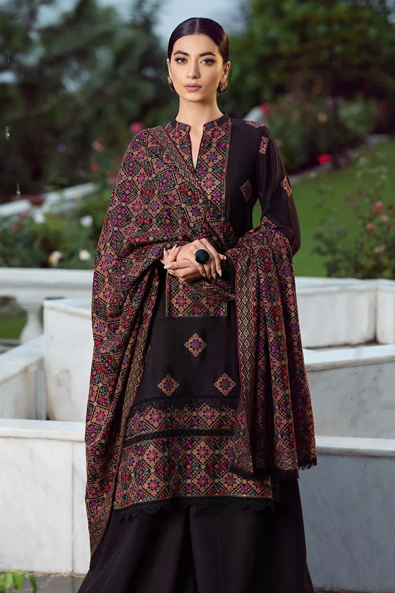 Woman wearing a black and patterned traditional outfit with a garden background